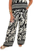 Front detail view of woman wearing Swagger Boutique’s Cream & Black Printed Tank & Wide Leg Pants against white studio background.
