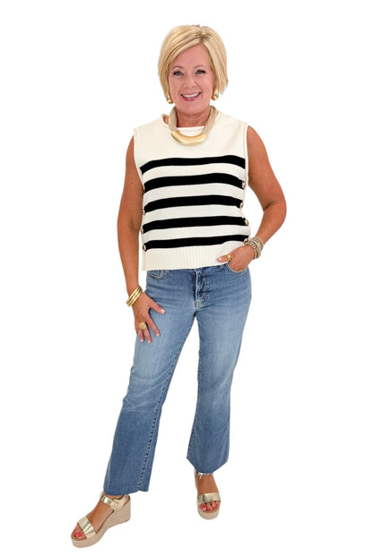 front view of woman wearing cap sleeve white and black striped knit sweater. 