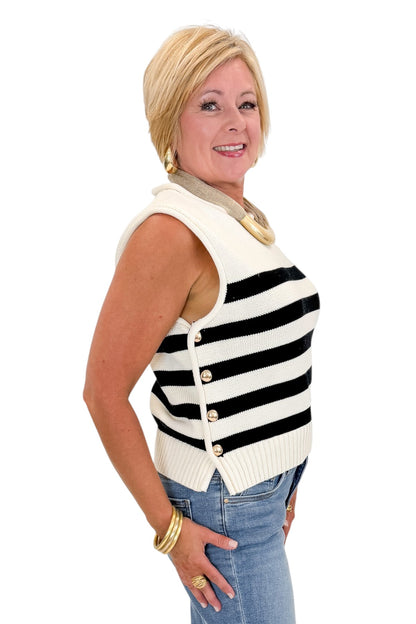 side view of woman wearing cap sleeve white and black striped knit sweater. 