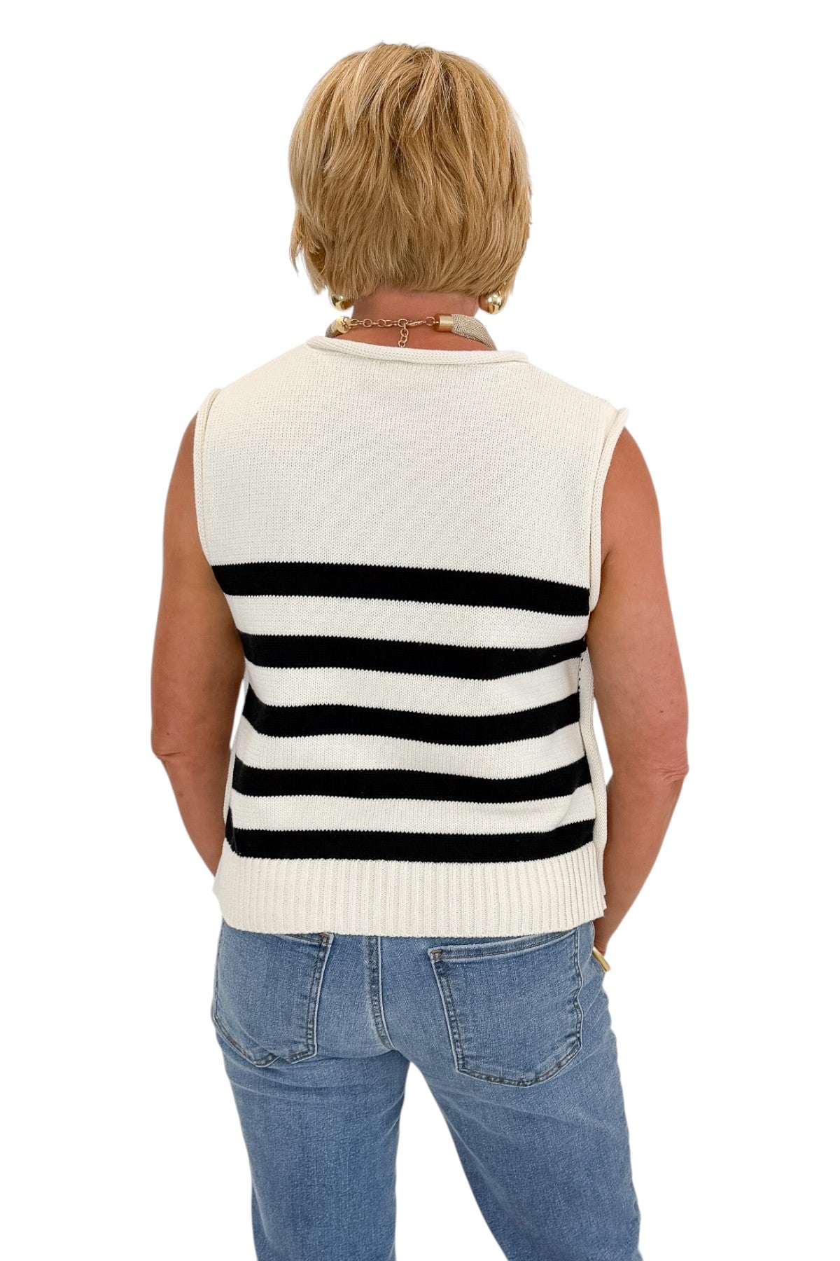 close up back view of woman wearing a cap sleeve white and black striped knit sweater. 
