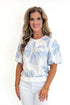 Front view of woman wearing Swagger Boutique’s Cream & Blue Floral Embroidered Top with jeans against white studio background.