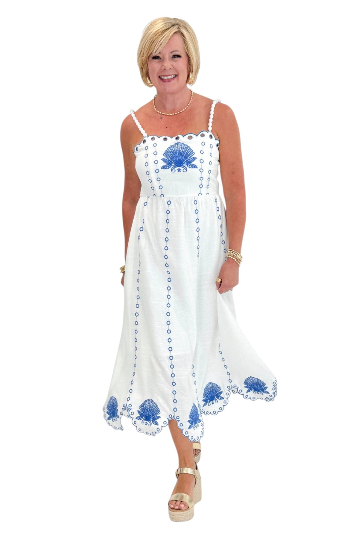 Front view of woman wearing Swagger Boutique’s Cream &amp; Blue Shell Embroidered Midi Dress with sandals against white studio background.