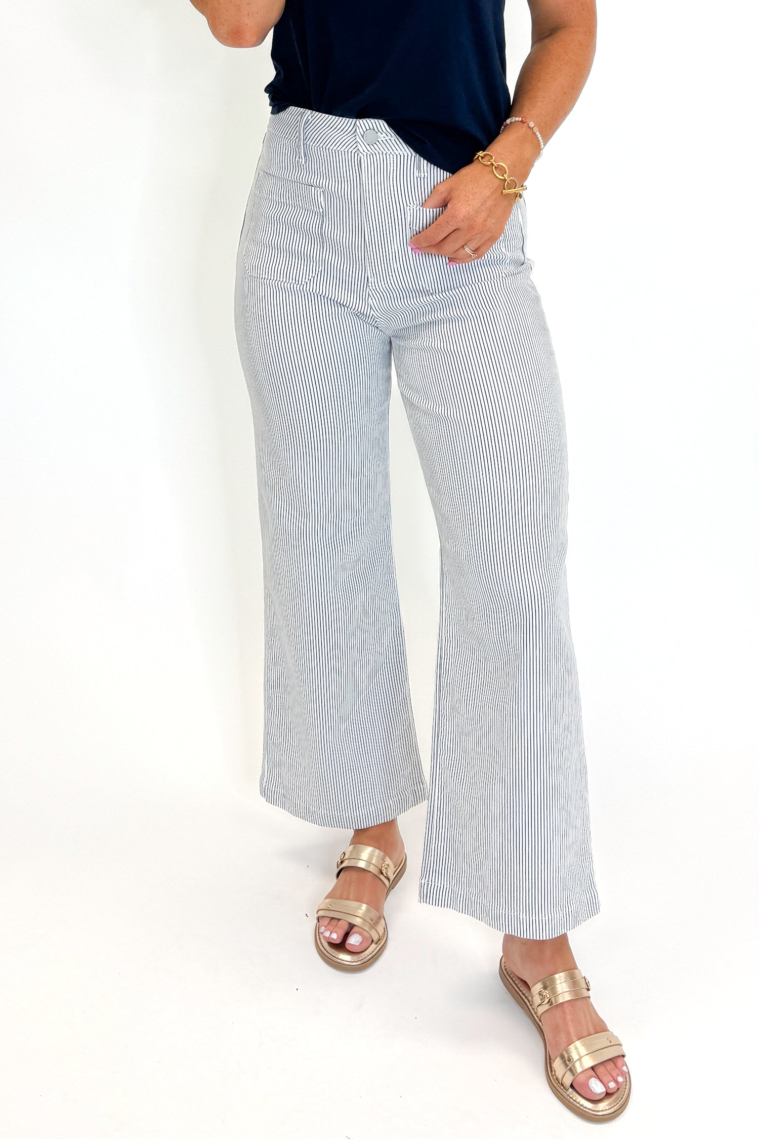 Front detail view of woman wearing Swagger Boutique’s Cream &amp; Blue Striped Jeans With Patch Pocket by Just Black Denim with blue Z Supply top against white studio background.