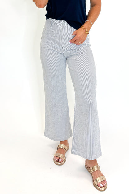 Front detail view of woman wearing Swagger Boutique’s Cream &amp; Blue Striped Jeans With Patch Pocket by Just Black Denim with blue Z Supply top against white studio background.