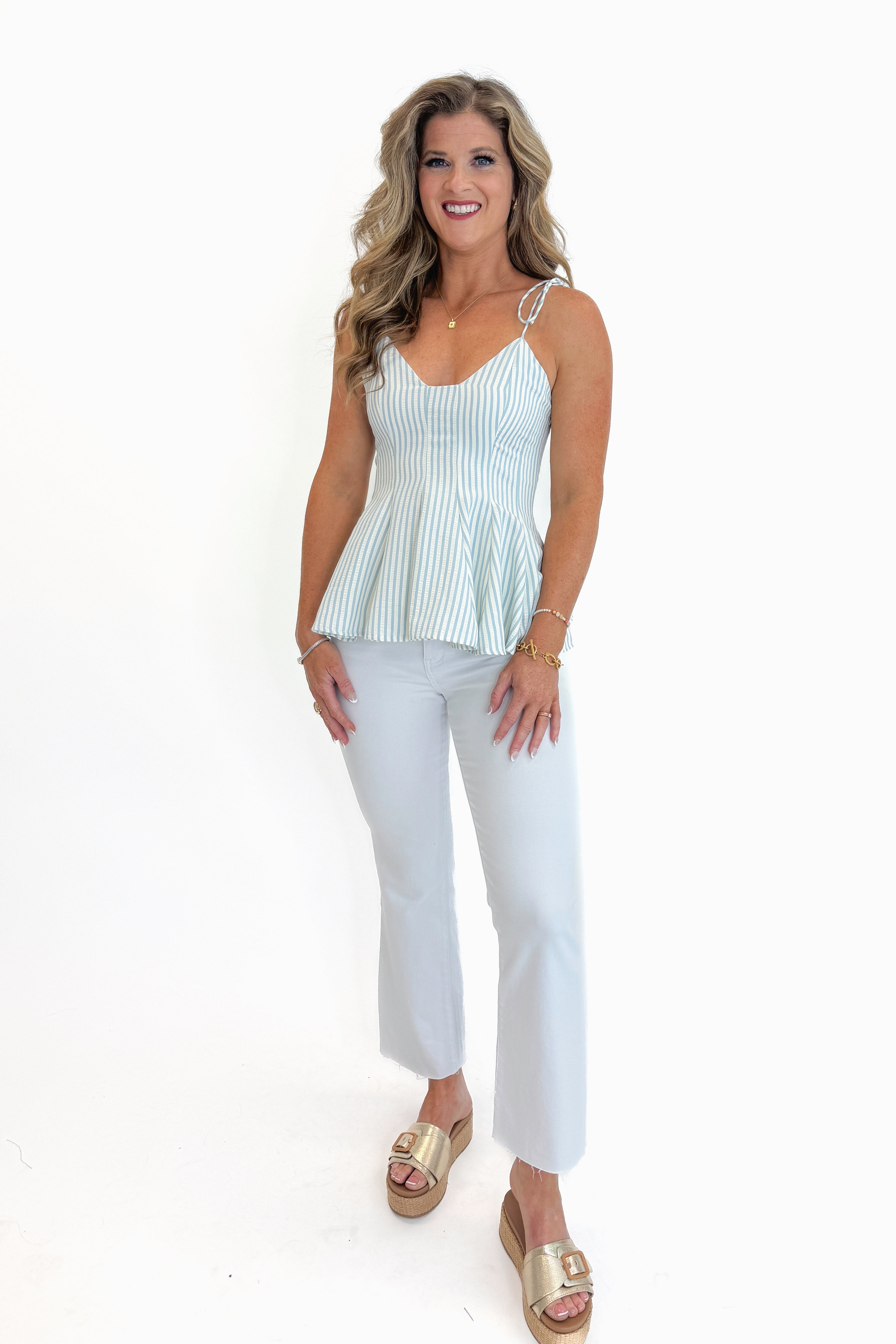 Front view of woman wearing Swagger Boutique’s Cream &amp; Blue Striped Tank with jeans against white studio background.