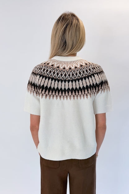 Back view of woman wearing Swagger Boutique’s Cream &amp; Brown Fair Isle Button Up Short Sleeve Sweater with Chocolate Brown Suede Pants against white studio background. 