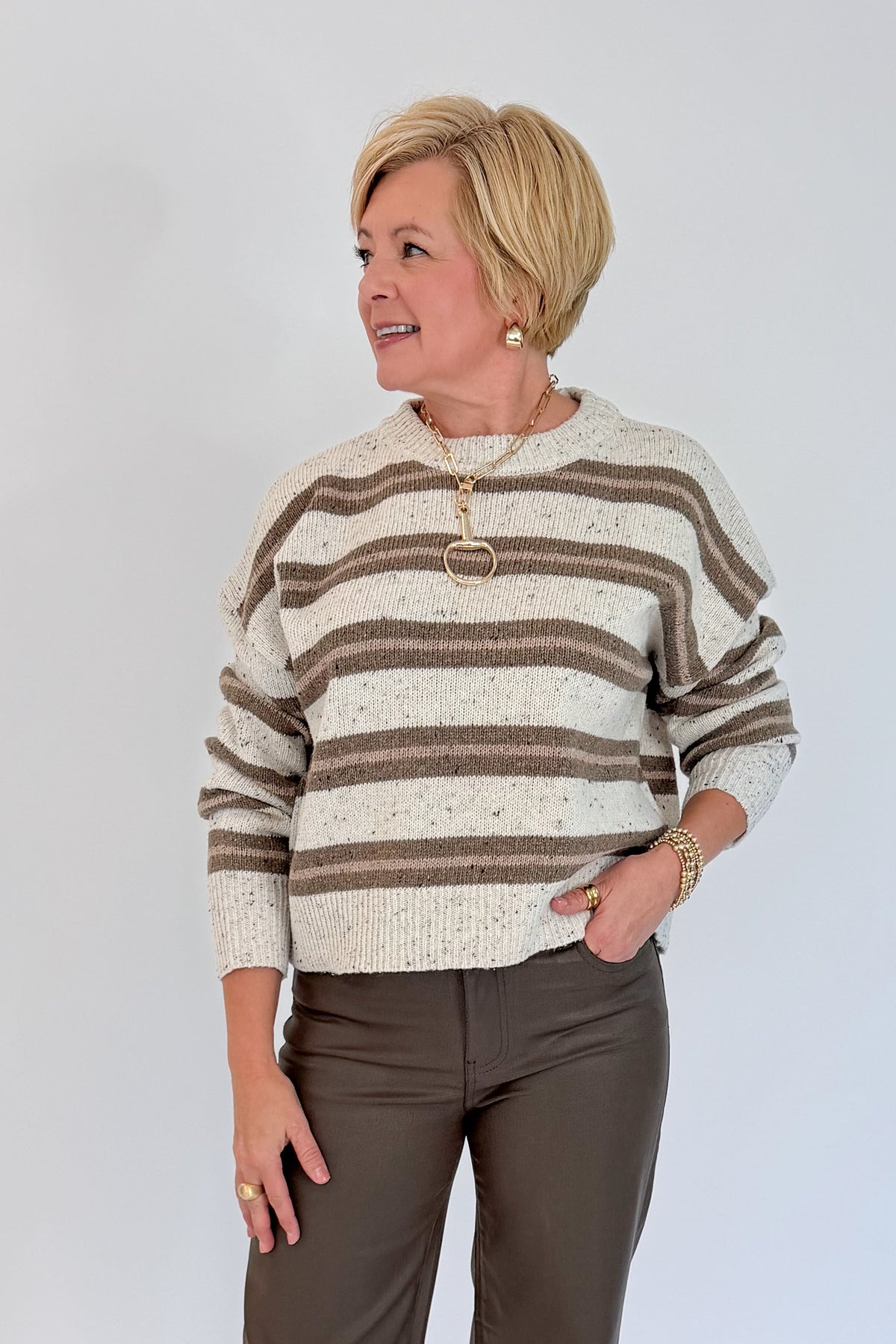 Front view of woman wearing Swagger Boutique’s Cream &amp; Brown Multi Striped Sweater with Meg Coated Wide Leg Jeans in Toffee by Kut from the Kloth against white studio background.