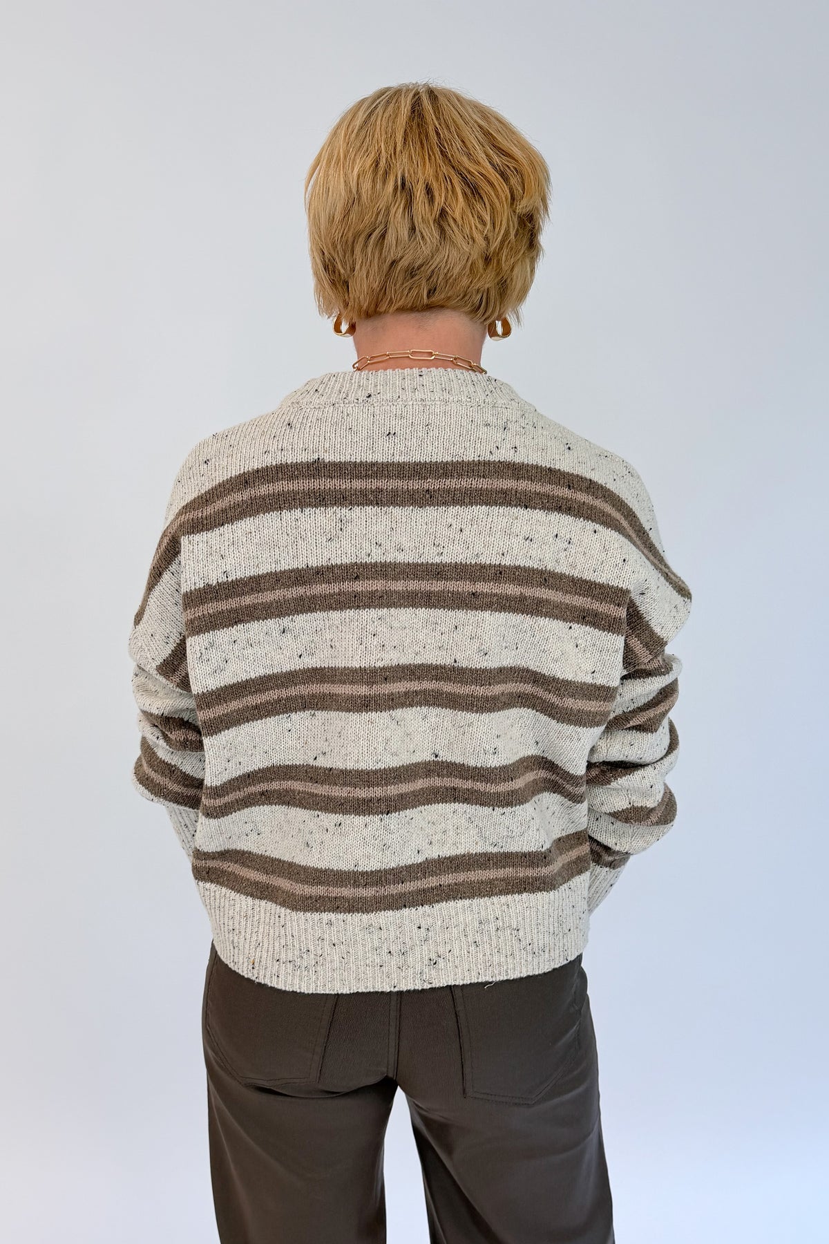 Back view of woman wearing Swagger Boutique’s Cream &amp; Brown Multi Striped Sweater with Meg Coated Wide Leg Jeans in Toffee by Kut from the Kloth against white studio background.