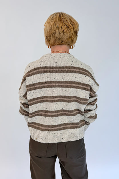 Back view of woman wearing Swagger Boutique’s Cream &amp; Brown Multi Striped Sweater with Meg Coated Wide Leg Jeans in Toffee by Kut from the Kloth against white studio background.
