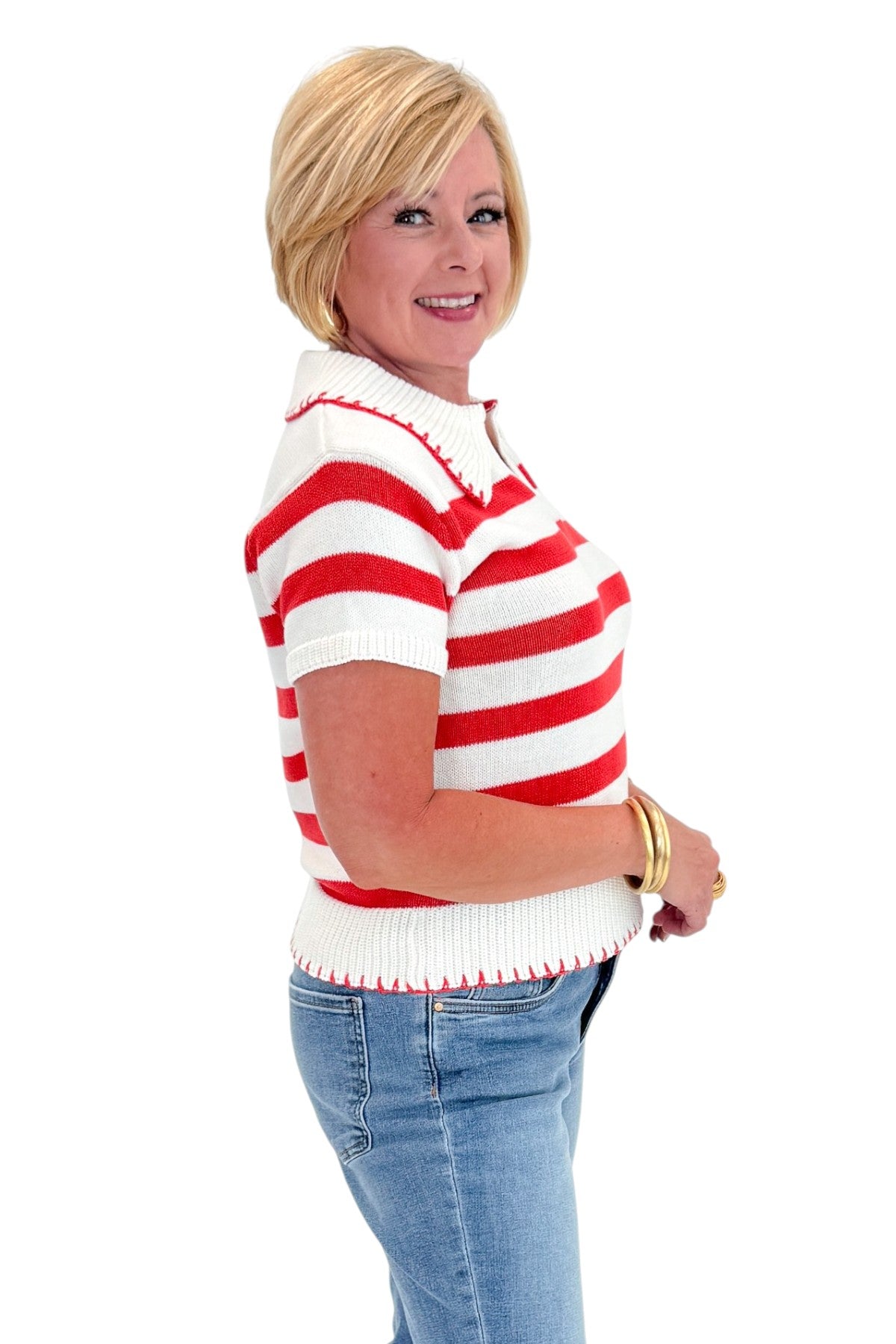 Side view of woman wearing Swagger Boutique’s Cream &amp; Coral Striped Knit Top with jeans against white studio background.