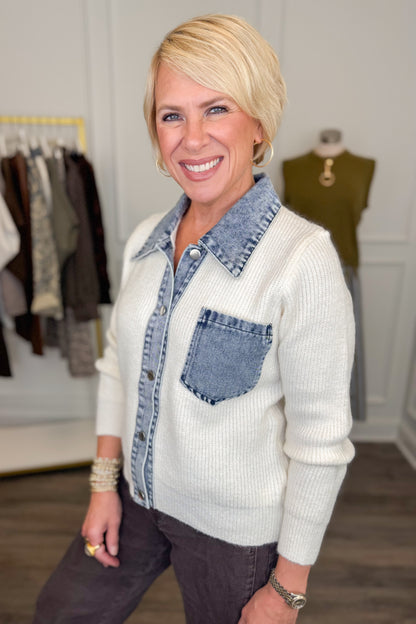 Side view of woman wearing Swagger Boutique’s Cream &amp; Denim Collared Button Up Sweater with Kelsey Coated Ankle Flare Jeans in Chocolate by Kut from the Kloth with clothing hanging in the background.