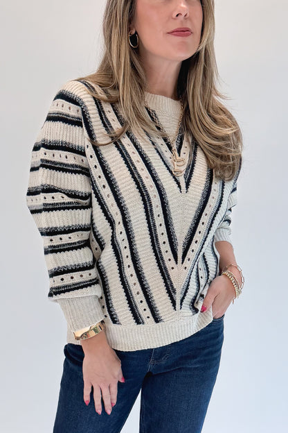 Front detail view of woman wearing Swagger Boutique’s Cream &amp; Navy Chevron Sweater with jeans against white studio background.