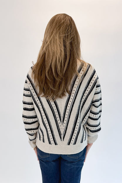 Back view of woman wearing Swagger Boutique’s Cream &amp; Navy Chevron Sweater with jeans against white studio background.