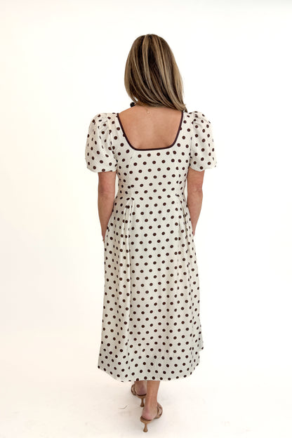 Back view of woman wearing Cream With Brown Stripe Detail Polka Dot Midi Dress by Entro against white studio background.