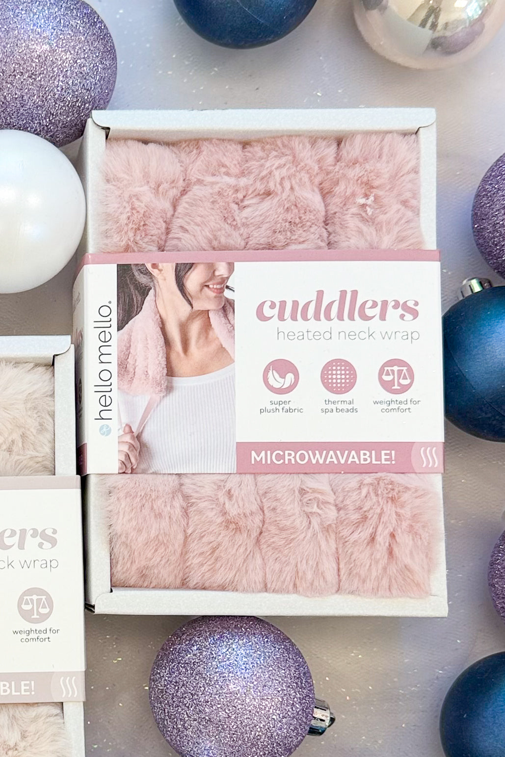 Cuddlers Heated Neck Wrap against holiday background pink