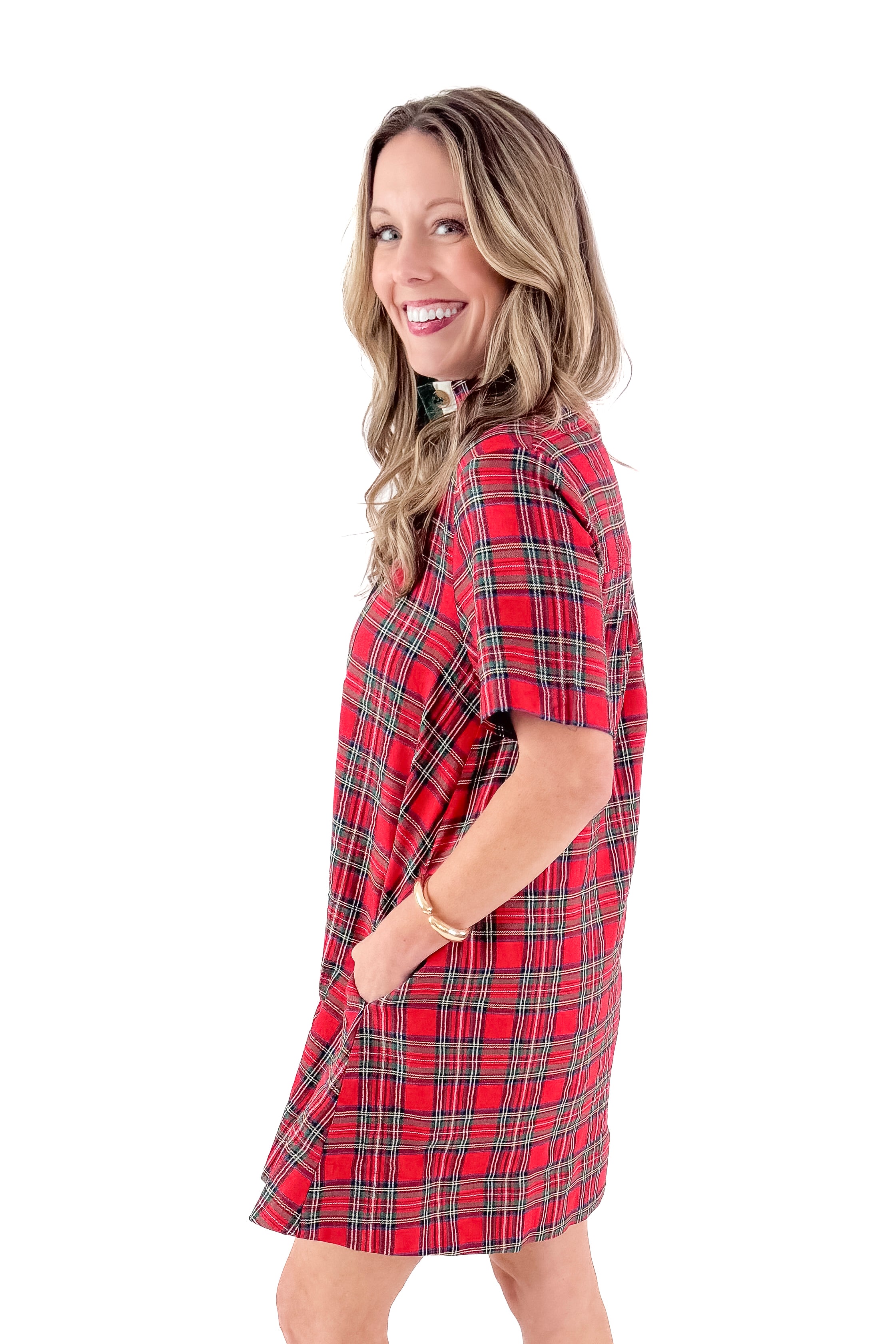 Side view of woman wearing Red Gingham Dress by Entro with boots against white studio background.