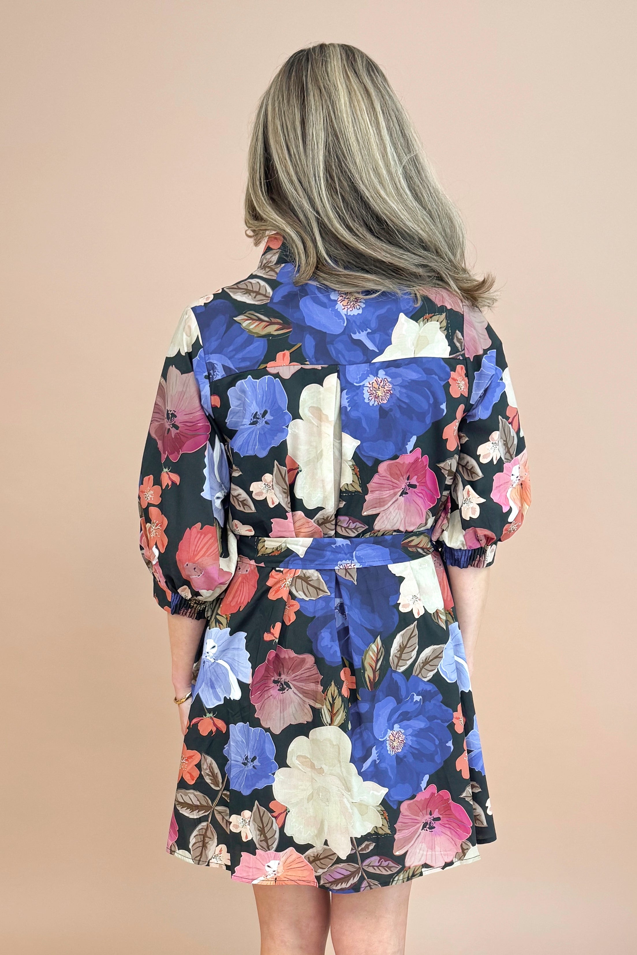 Woman in Black button-up mini dress with colorful floral print, featuring puff sleeves and self-tie waist by Entro