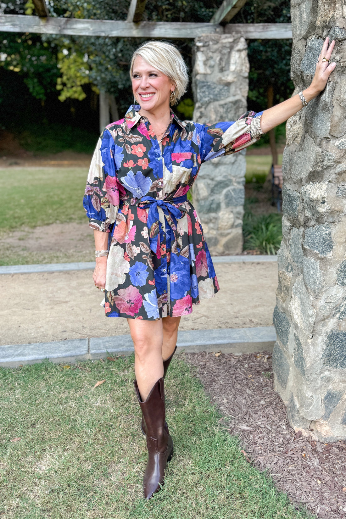 Black button-up mini dress with colorful floral print, featuring puff sleeves and self-tie waist by Entro
