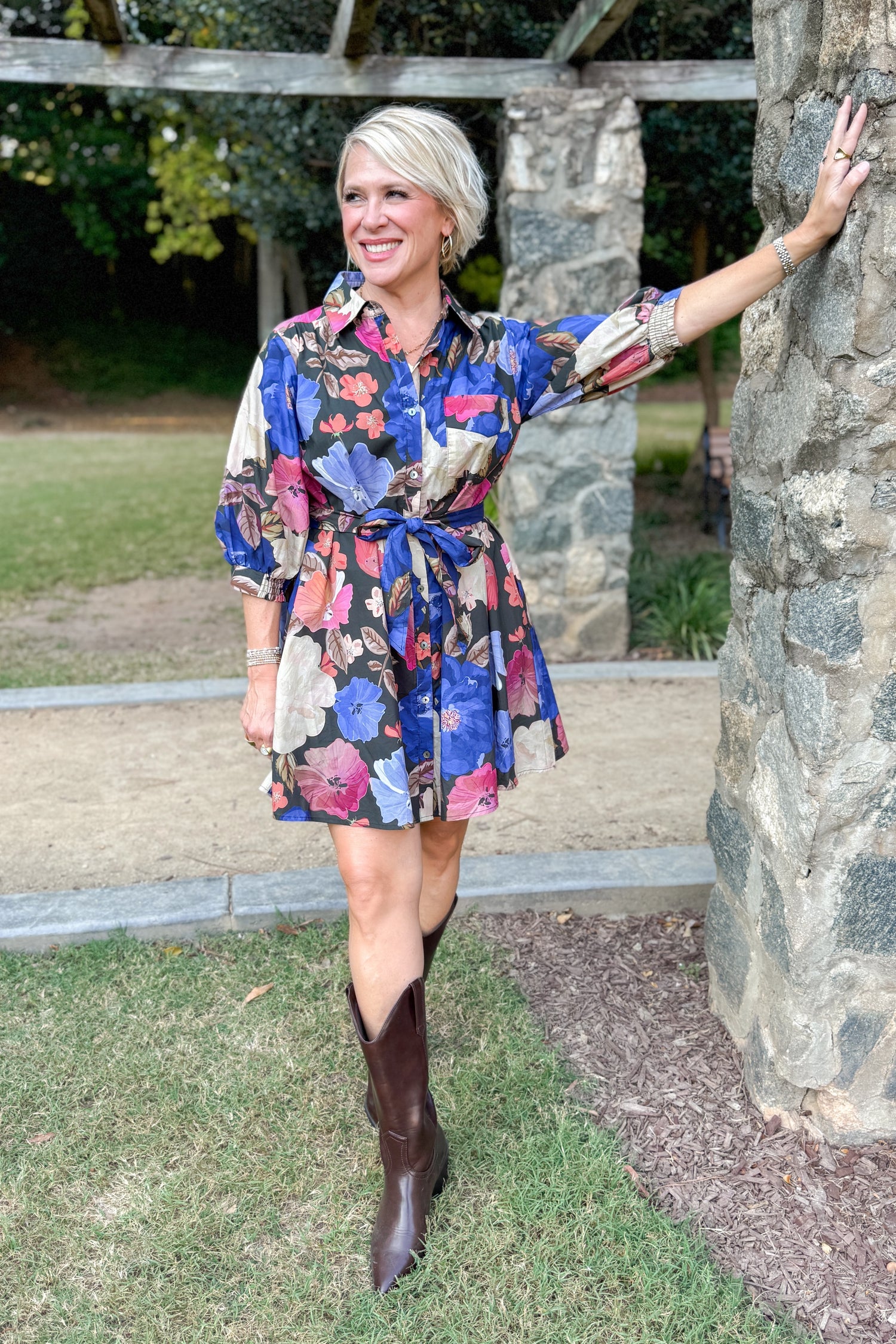 Black button-up mini dress with colorful floral print, featuring puff sleeves and self-tie waist by Entro