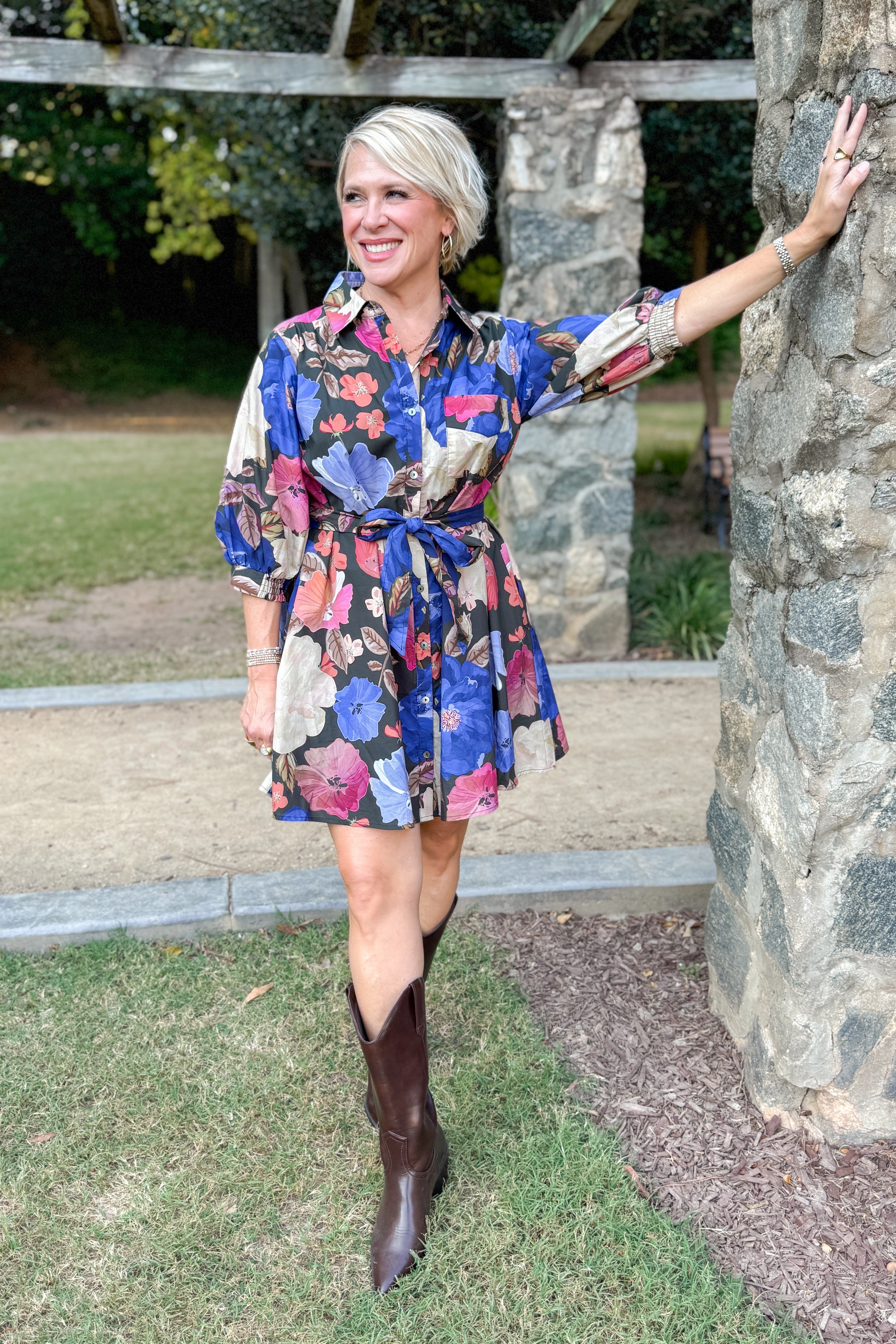 Black button-up mini dress with colorful floral print, featuring puff sleeves and self-tie waist by Entro