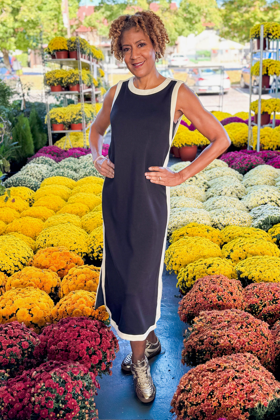 Outdoor picture of woman wearing Black With Cream Lining Midi Dress by Entro with mums in the background.