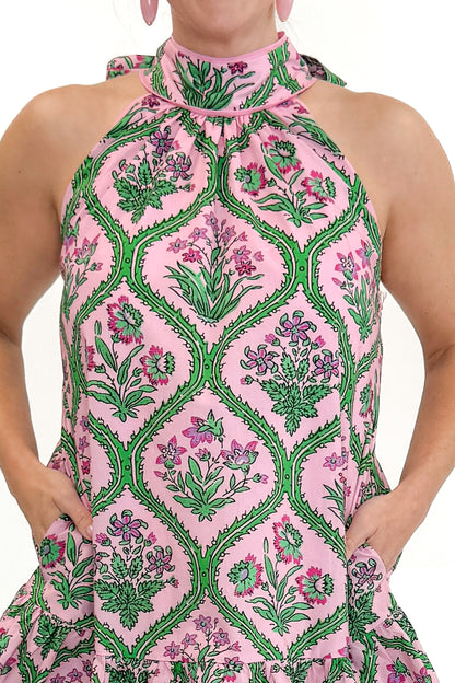 Front detail view of woman wearing Pink &amp; Green Floral Halter Neck Dress by Entro against white studio background.