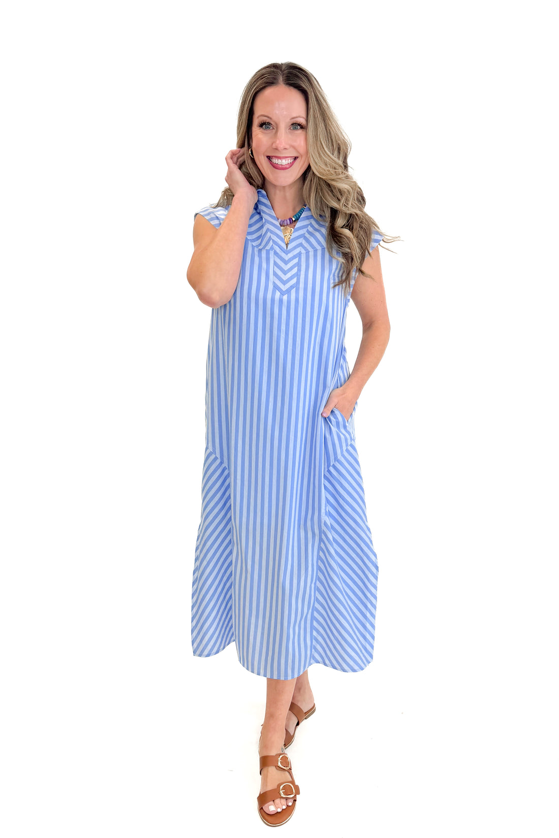 Front view of woman wearing Light Blue Striped Panel Detail Dress by Entro with sandals against white studio background.