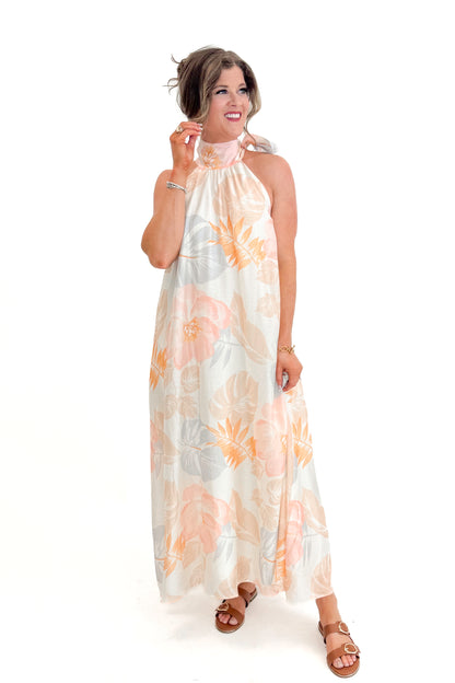 Front view of woman wearing Multi Tropical Printed Tie Neck Maxi Dress by Entro with sandals against white studio background.