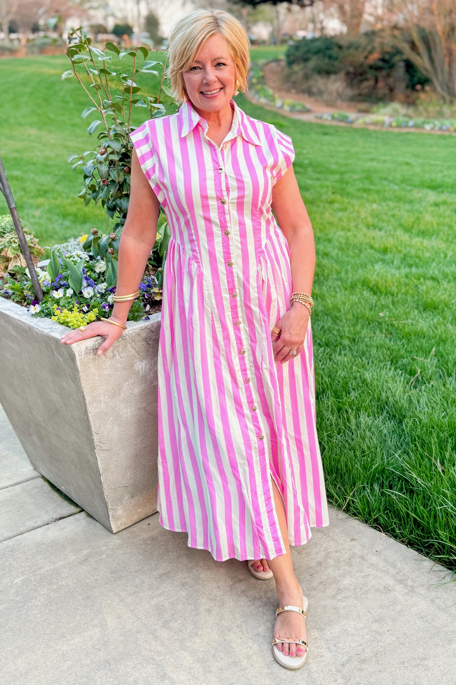 Front view of woman wearing Pink Striped Button Down Midi Dress by Entro with sandals outside at a garden.