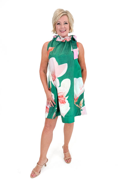 Front view of woman wearing Green Floral Tie Neck Mini Dress against white studio background.