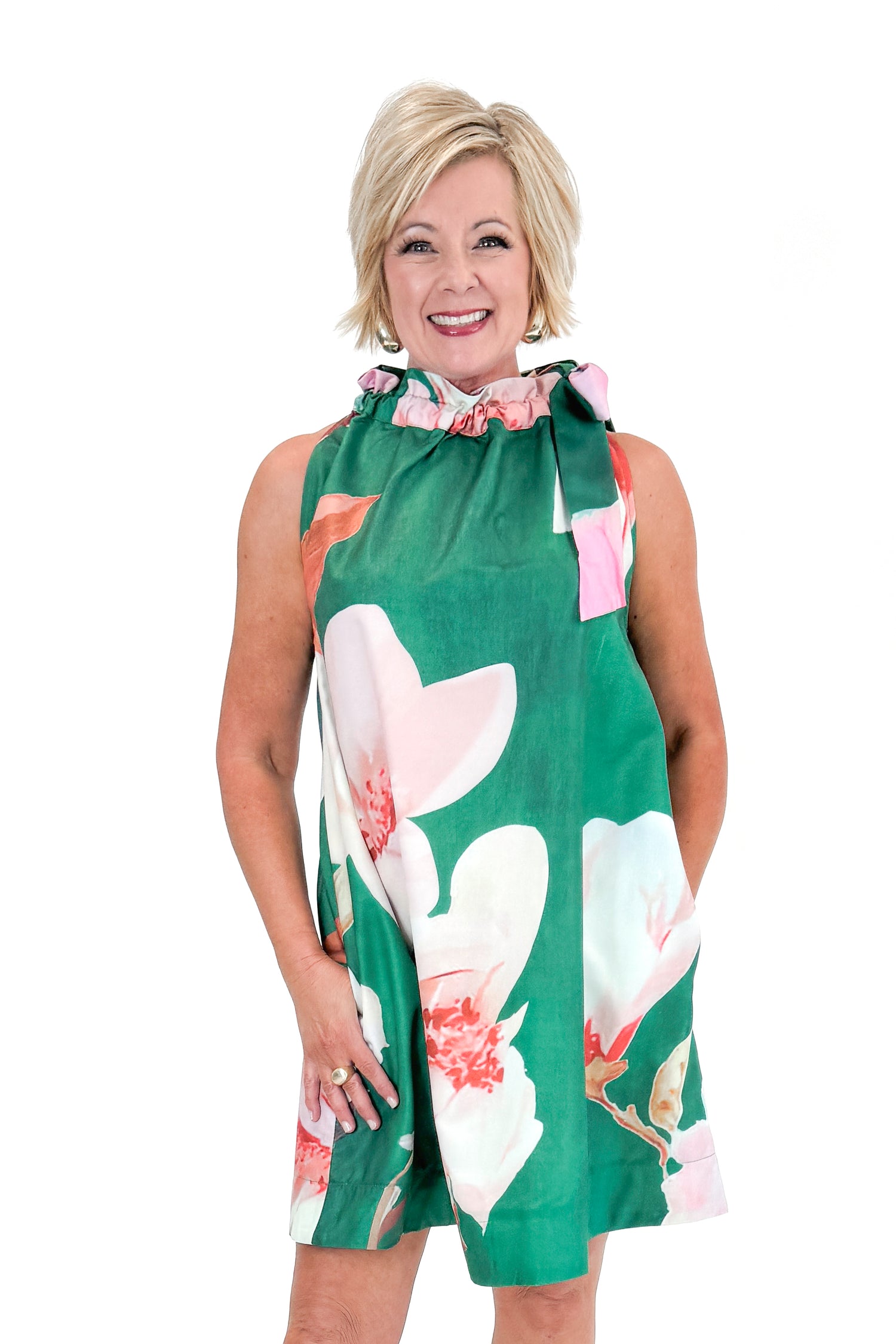 Front view of woman wearing Green Floral Tie Neck Mini Dress against white studio background.