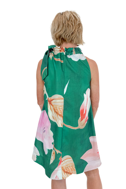 Back view of woman wearing Green Floral Tie Neck Mini Dress against white studio background.