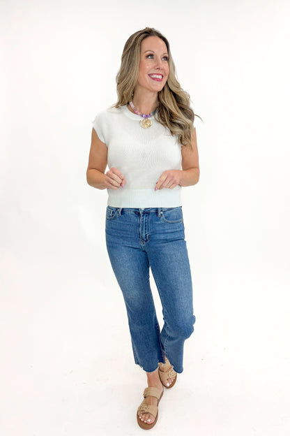 Front view of woman wearing Medium Wash Kick Crop Jeans by Just Black Denim with sweater against white studio background.