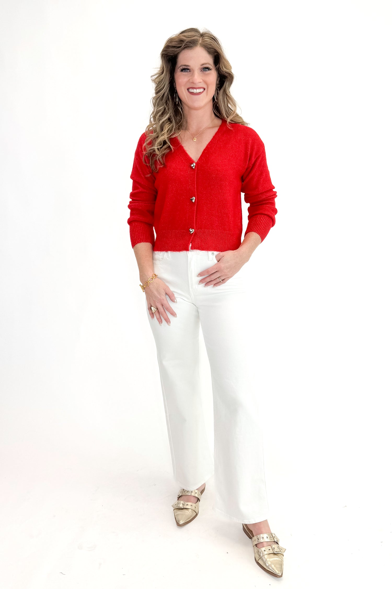Front view of woman wearing red sweater with White Straight Leg Jeans by Just Black Denim against white studio background.