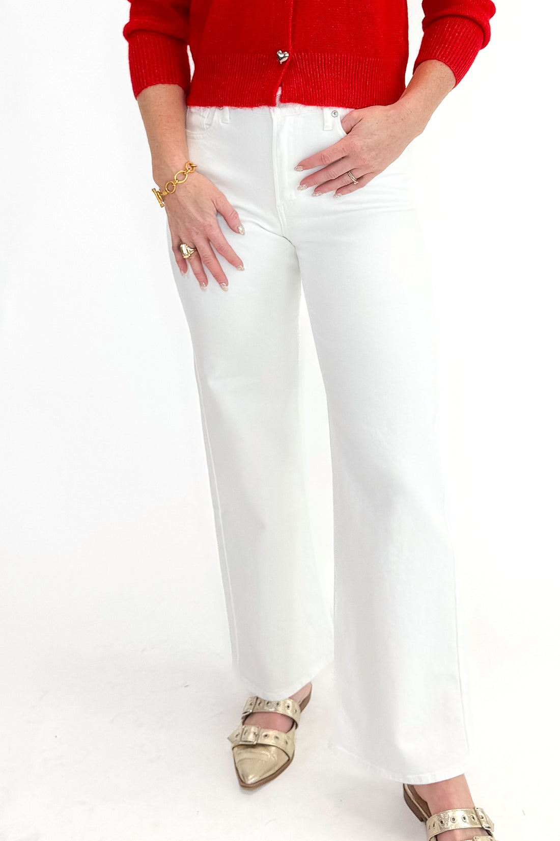 Front detail view of woman wearing red sweater with White Straight Leg Jeans by Just Black Denim against white studio background.