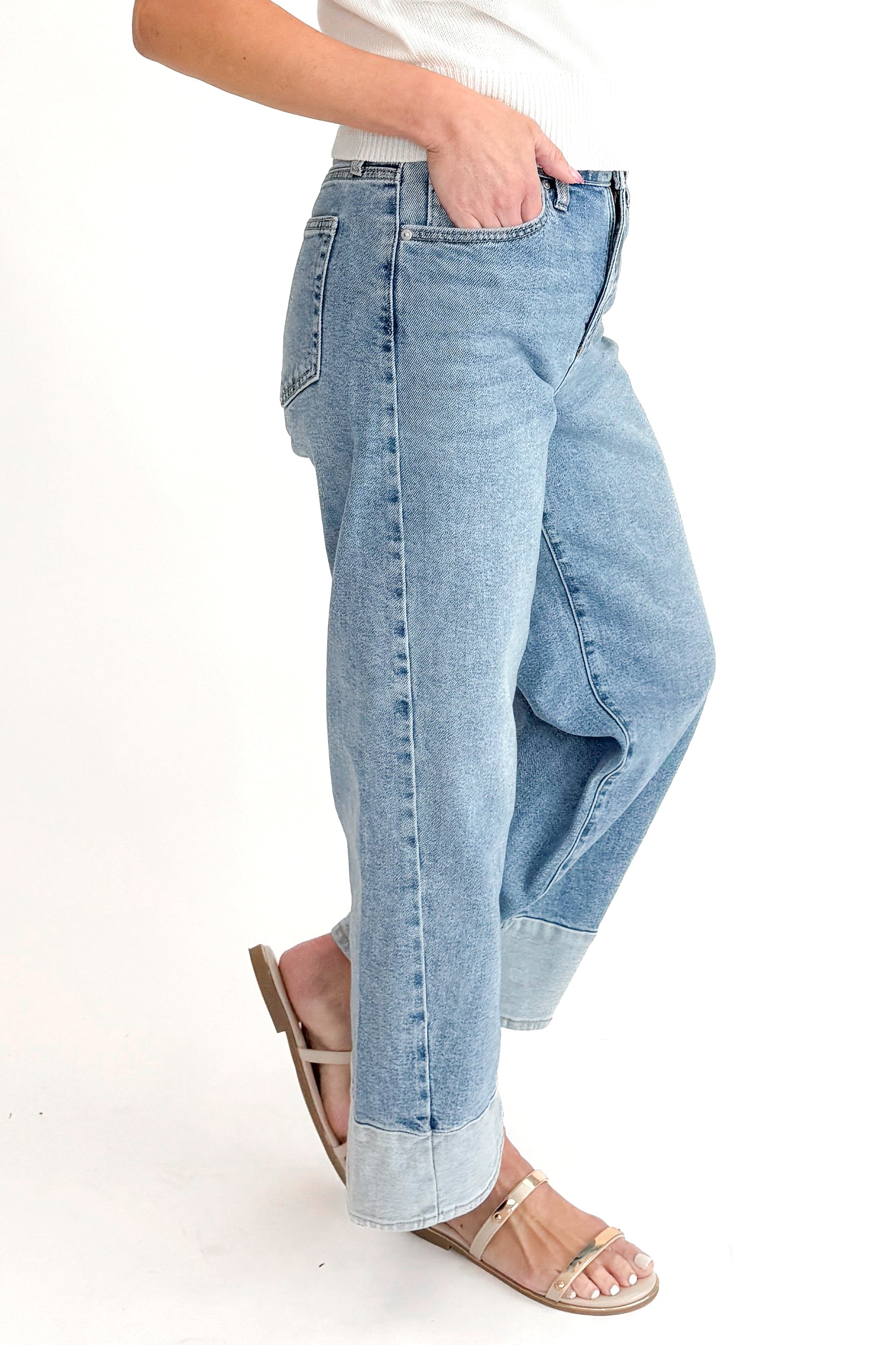 Side view of woman wearing Light Wash Two Toned Jeans by Just Black Denim with white sweater against white studio background.