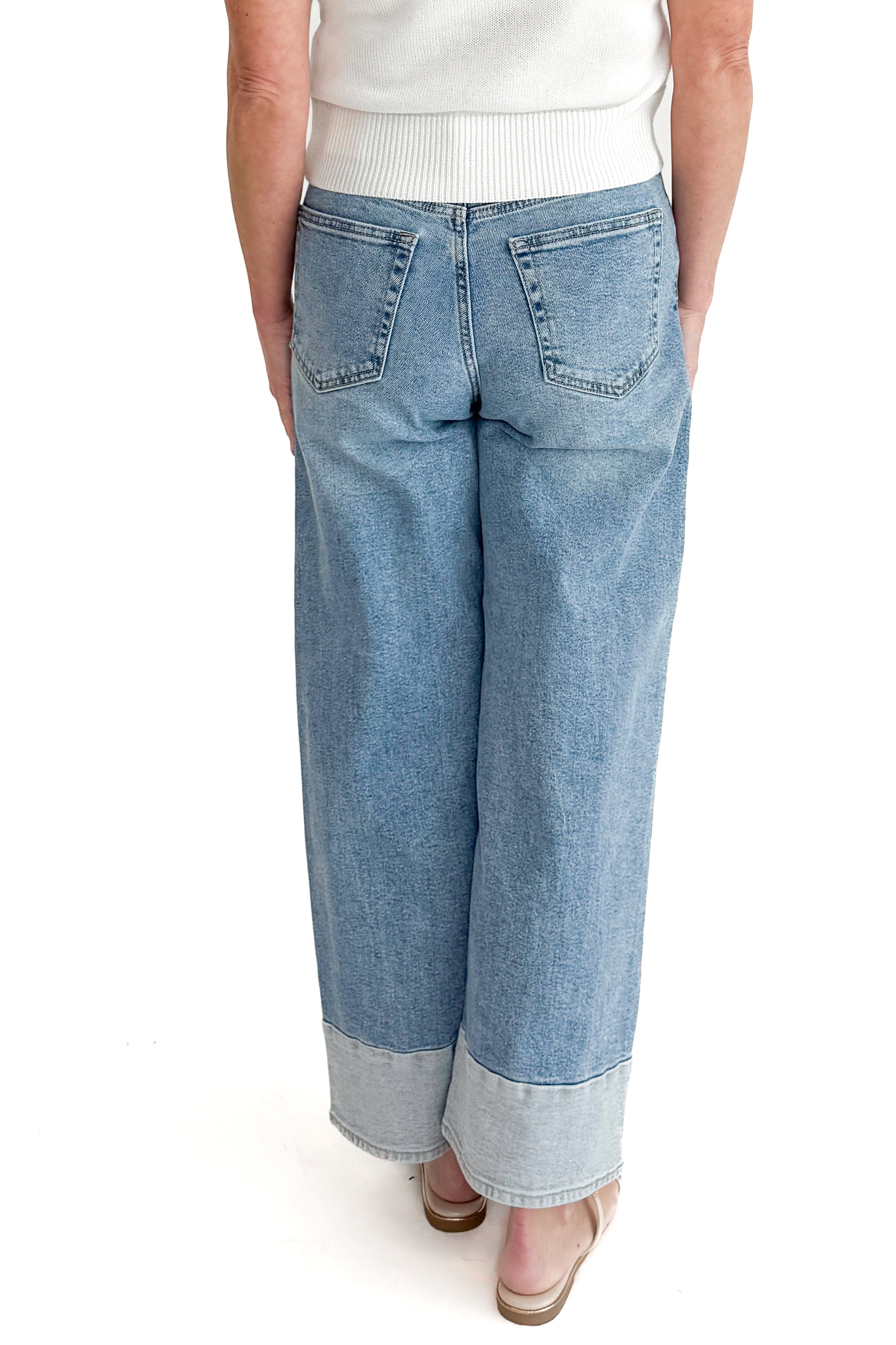 Back view of woman wearing Light Wash Two Toned Jeans by Just Black Denim with white sweater against white studio background.