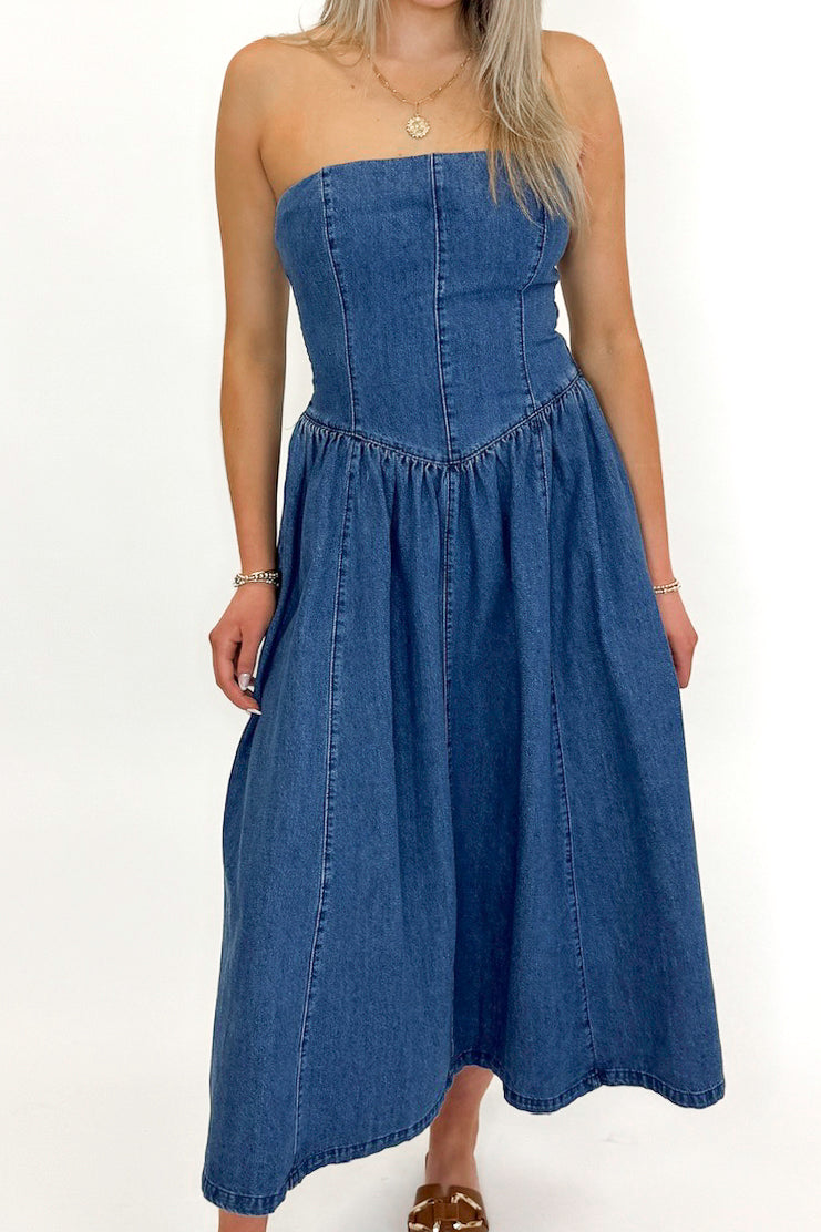 Front detail view of woman wearing Denim V-Waist Midi Dress with sandals against white studio background.