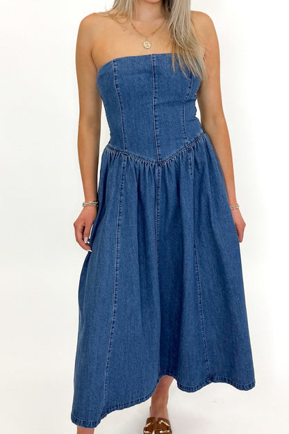 Front detail view of woman wearing Denim V-Waist Midi Dress with sandals against white studio background.