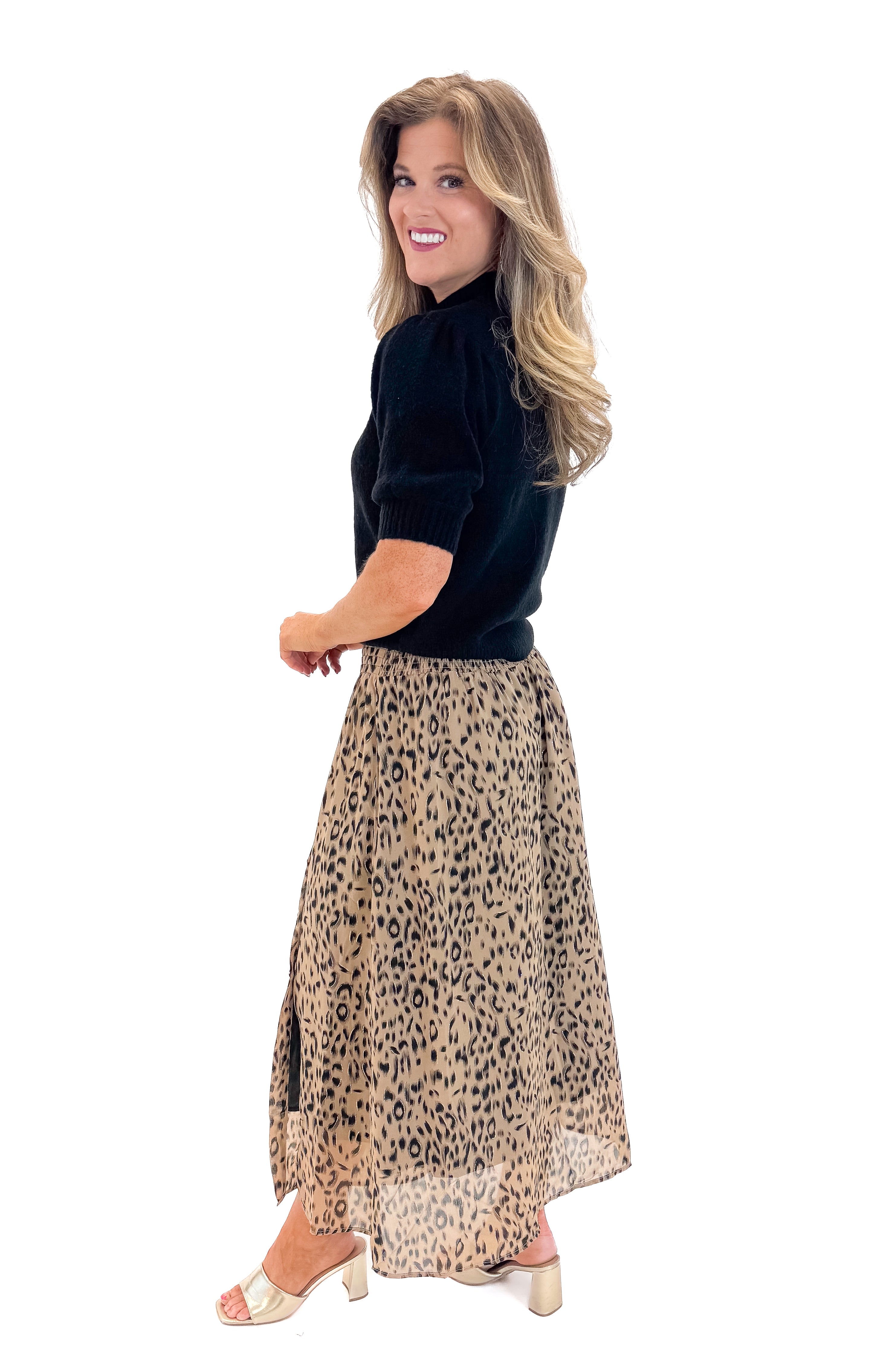 SIde view of woman wearing Black Puff Short Sleeve Sweater with Beige Leopard Button Detail Skirt against white studio background.