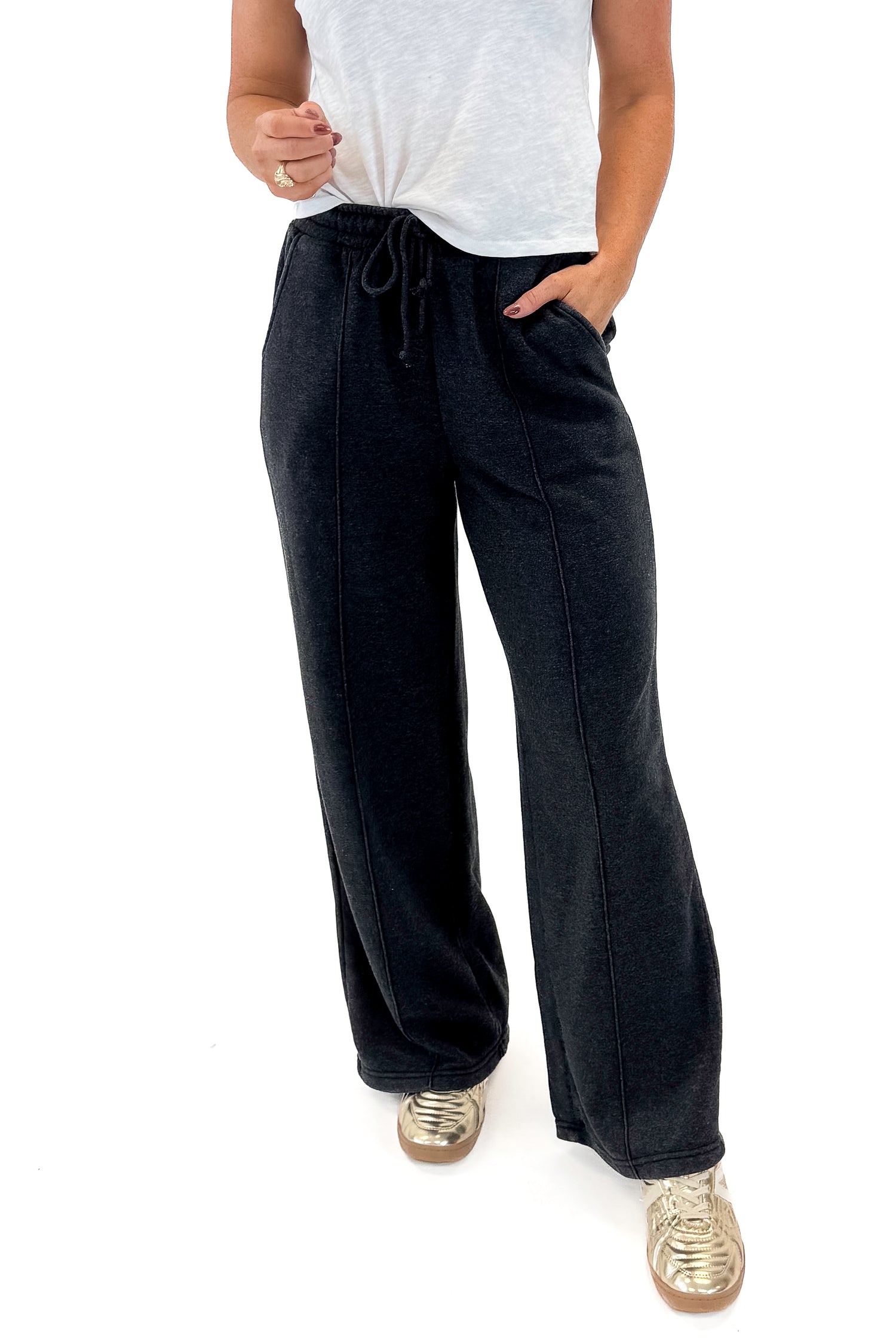 Front view of woman wearing Washed Black Drawstring Sweatpants with white top against white studio background.