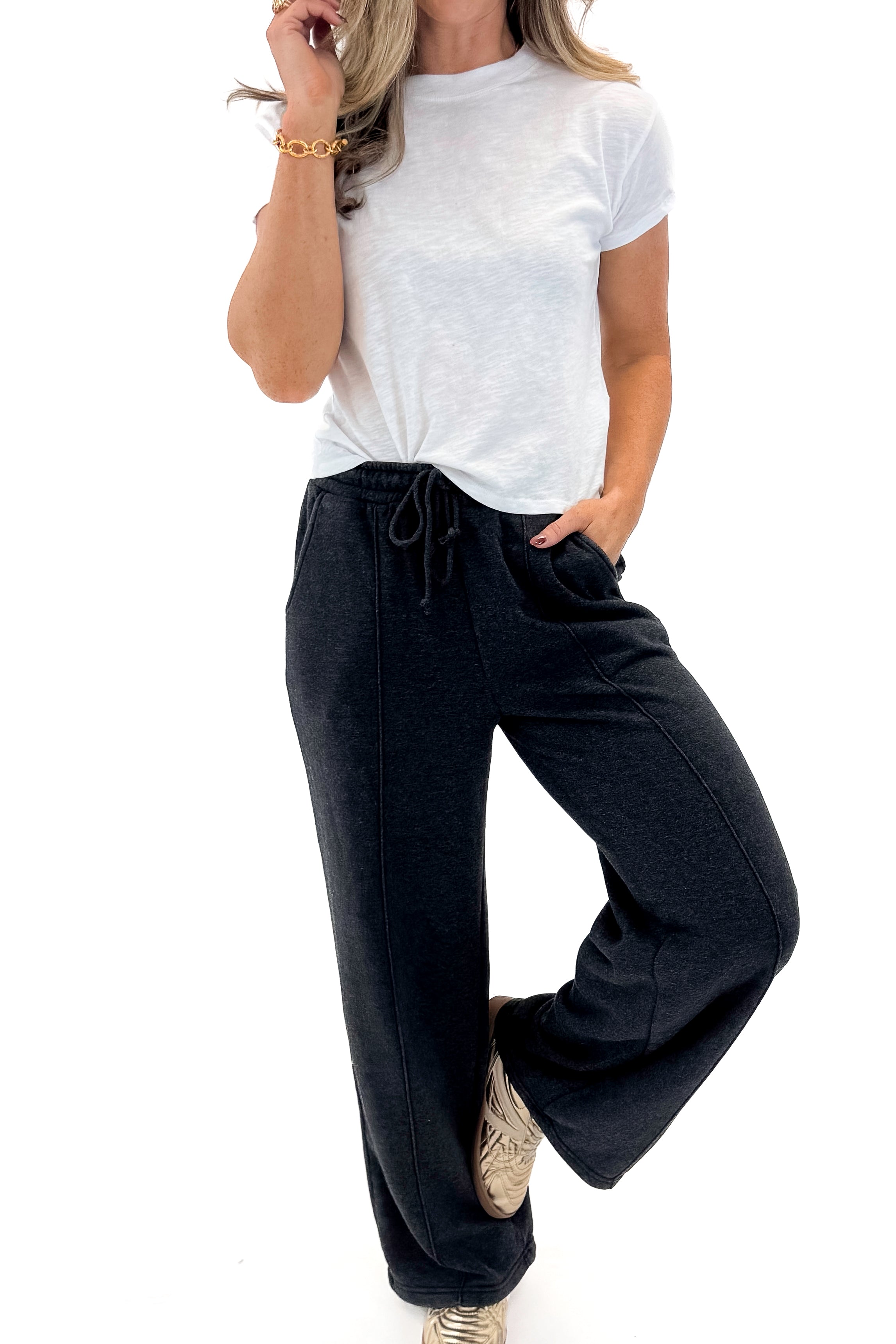 Front view of woman wearing Washed Black Drawstring Sweatpants with white top against white studio background.