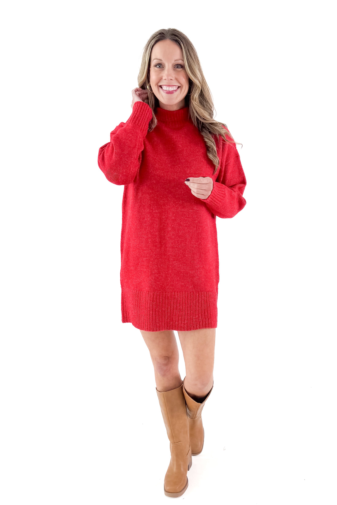 Front view of woman wearing red sweater dress with boots against white studio background.