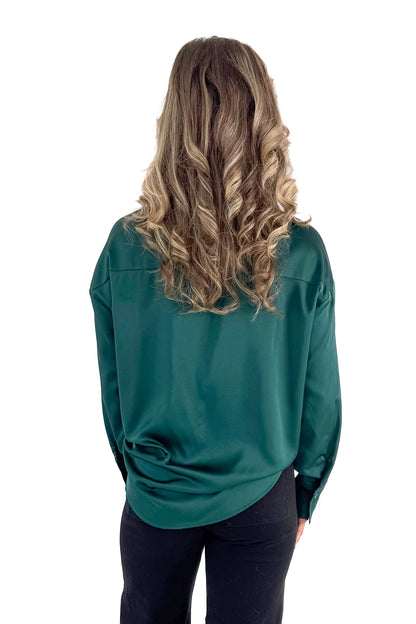 Back view of woman wearing Green Satin Collared V-neck Top with jeans against white studio background.