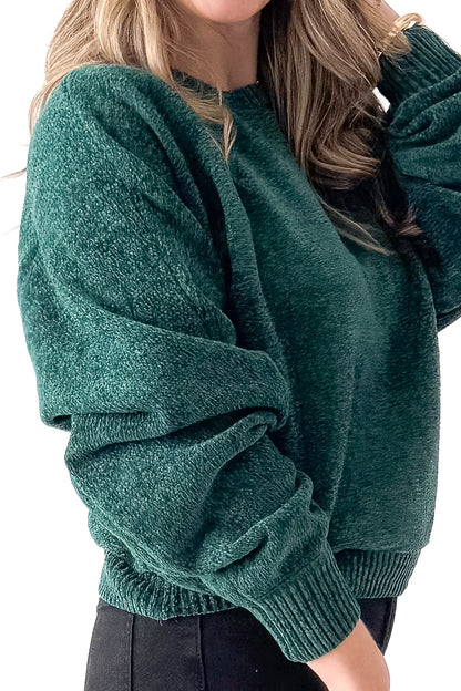 Side detailed view of woman wearing Hunter Green Chenille Sweater with jeans against white studio background.