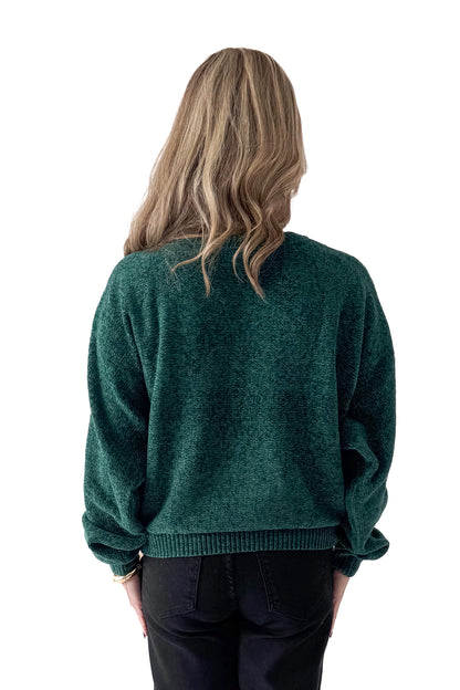 Back view of woman wearing Hunter Green Chenille Sweater with jeans against white studio background.