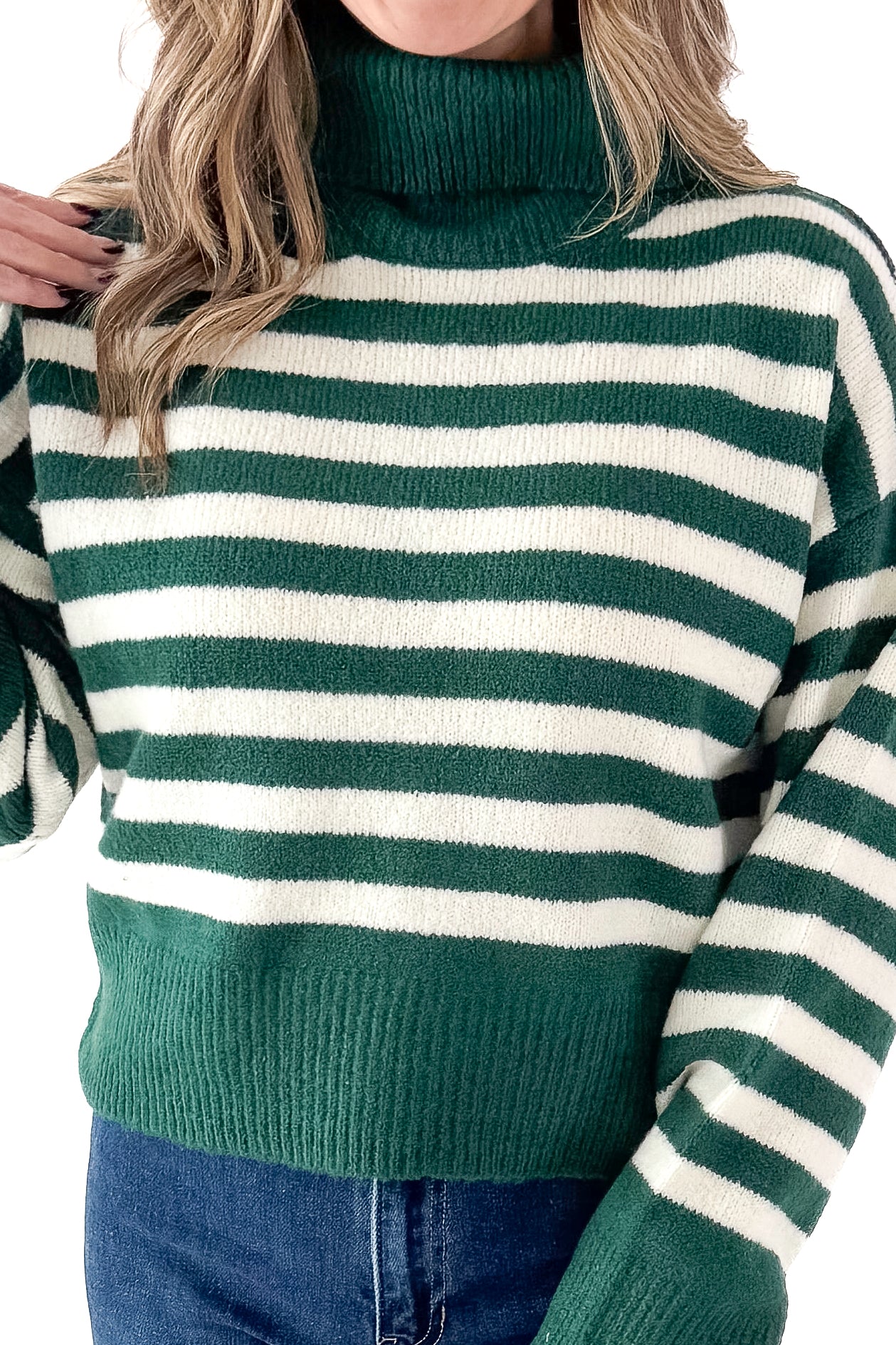 Front detailed view of woman wearing Green &amp; Cream Striped Turtleneck Sweater with jeans against white studio background.