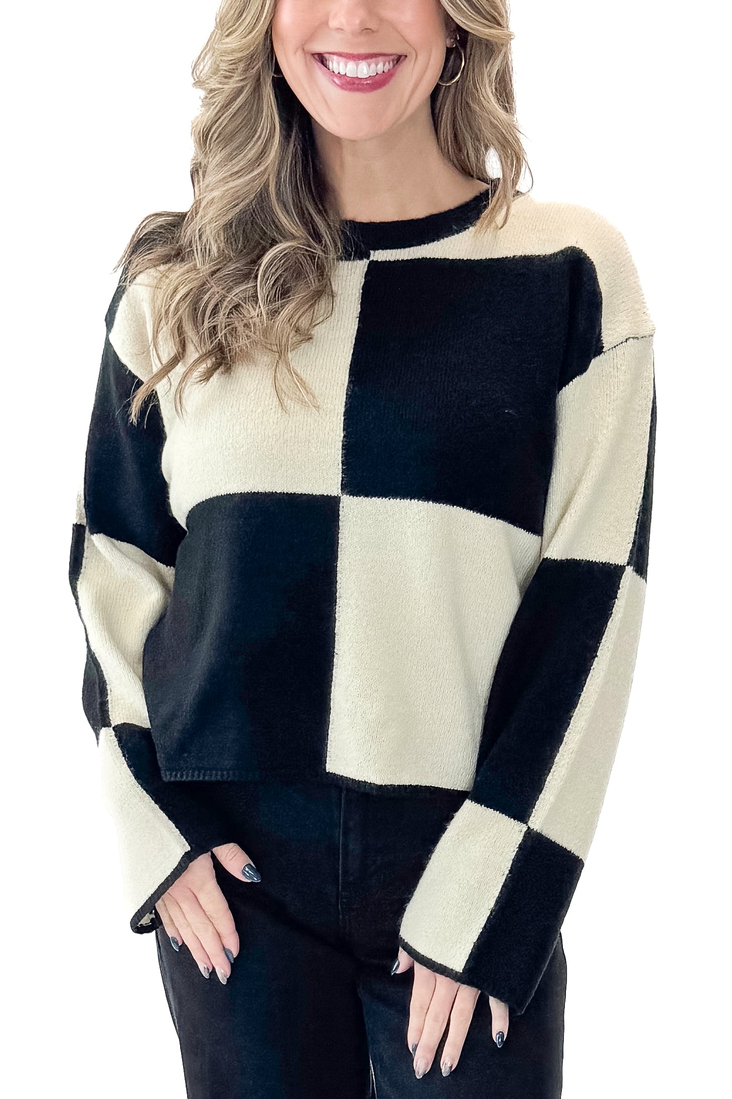 Front view of woman wearing Black &amp; Cream Checkered Sweater with jeans against white studio background.
