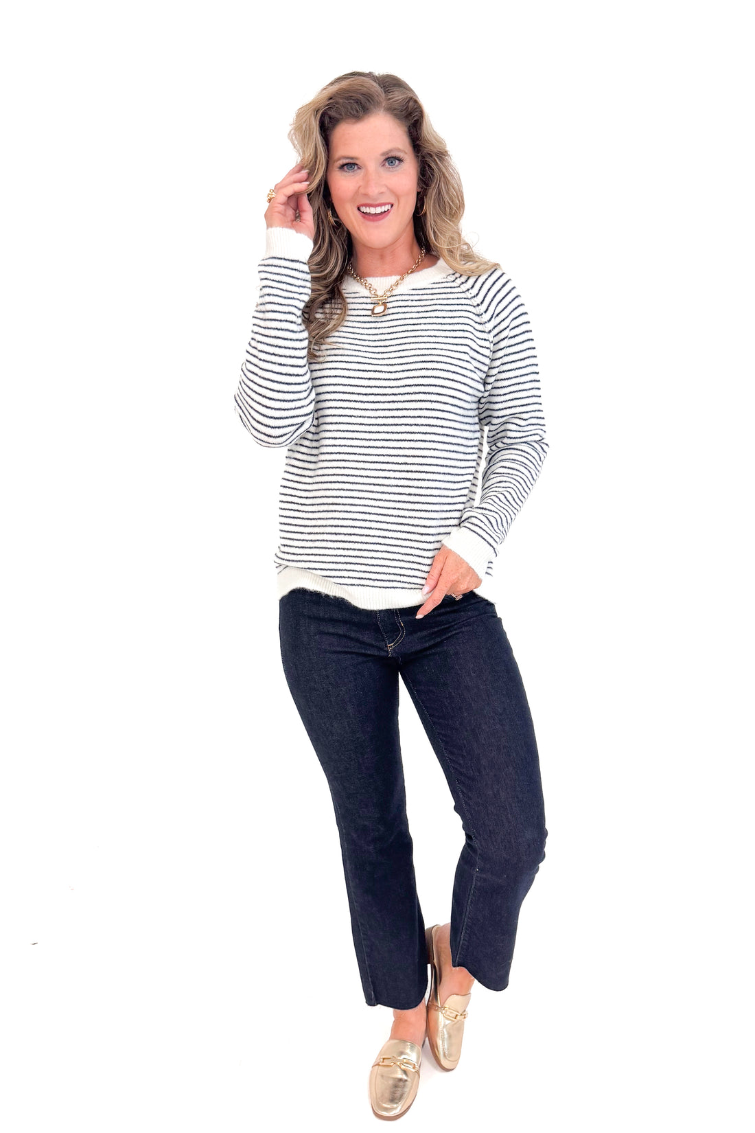Woman wearing Cream &amp; Black Striped Long Sleeve Top and blue jeans full front length.