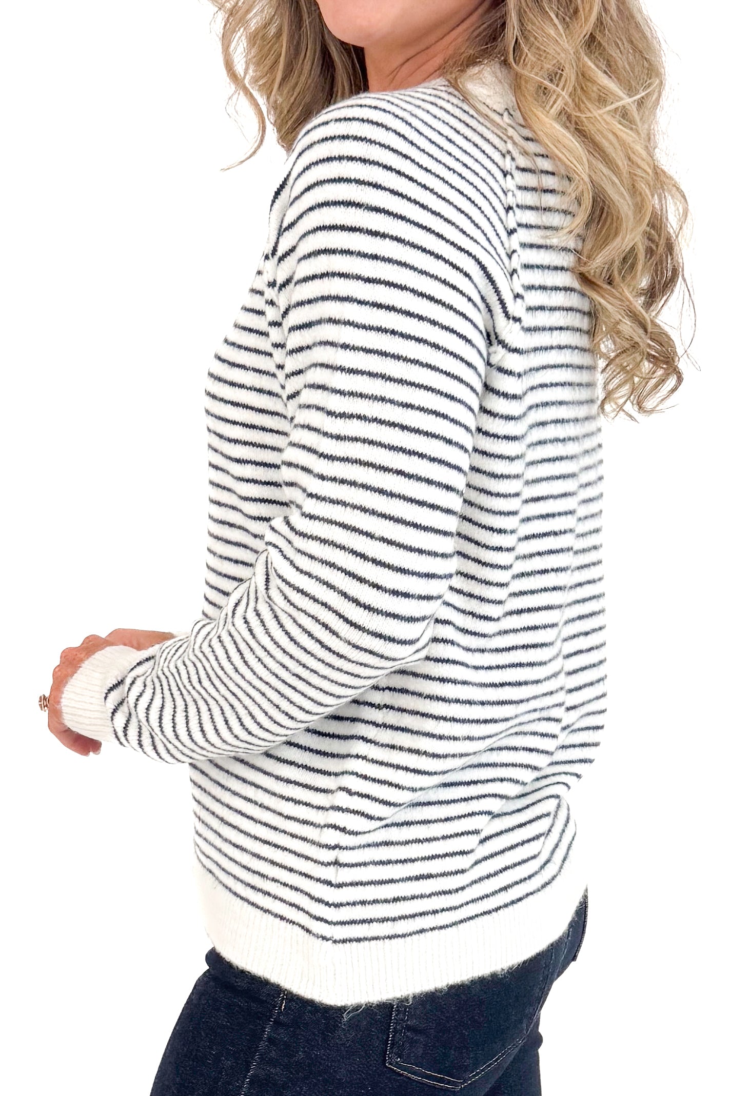Side detail view of woman wearing Cream &amp; Black Striped Long Sleeve Top and blue jeans. 
